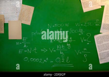 formules mathématiques et papiers sur un tableau vert - tableau noir et le concept scolaire Banque D'Images