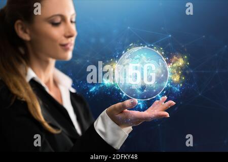 Femme d'affaires présentant une carte du monde virtuel avec le message 5G dans avant d'un arrière-plan bleu abstrait Banque D'Images