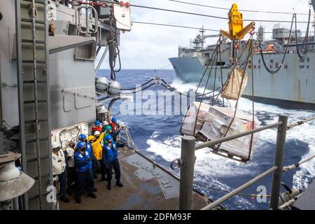 Photo du 2 novembre 2020 des marins à bord du croiseur à missiles guidés de classe Ticonderoga USS Shiloh (CG 67) reçoivent des palettes de nourriture du navire de cargaison sèche et de munitions USNS Alan Shepard (T-AKE 3) lors d'un réapprovisionnement en mer pendant Keen Swen 21. Les forces de commandement américaines Indo-Pacifique et les unités de la Force d'autodéfense du Japon ont commencé lundi l'exercice Keen Sword 21 sur les installations militaires dans le Japon continental. L'exercice biennal conjoint de formation sur le terrain pour les unités militaires américaines et de la Force d'autodéfense du Japon vise à renforcer les relations bilatérales entre le Japon et les États-Unis et à renforcer l'état de préparation au combat, le Banque D'Images