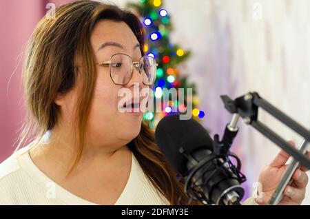 Une dame chantant dans un microphone, enregistrant des voix pour une chanson. Banque D'Images