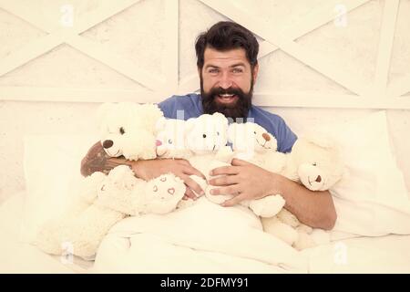 De retour dans l'enfance. Joyeux anniversaire. Homme avec barbe heureux visage tenir des jouets cadeaux. Boutique de jouets. Baccalauréat. Habitudes Puériles. Ours en peluche. Achats en ligne. Jouets pour adultes. Détendez-vous dans la chambre. Banque D'Images