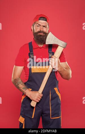 homme avec hache. forester tenir la hache. homme en uniforme couper les cheveux de barbe avec hache. homme barbu brutal utiliser hache dans les mains. Randonnée vacances. Assez courageux. Utilisez la lame dans le barbershop. Brutal et barbu. Banque D'Images