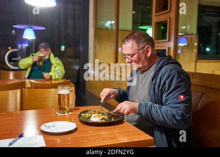 04 décembre 2020, Rhénanie-Palatinat, Waldlaubersheim: Le chauffeur de camion Ingo apprécie sa soirée à l'Autohof sur l'autoroute A61. Malgré les fermetures de restaurant liées à la couronne, les chauffeurs routiers sont toujours autorisés à utiliser l'offre gastronomique à de nombreux arrêts de camions. (À dpa : « nourriture chaude pour les chauffeurs de camions malgré la fermeture des restaurants ») photo : Thomas Frey/dpa Banque D'Images