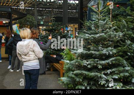 Londres, Royaume-Uni. 05e décembre 2020. Personnes prenant des photos à un kiosque téléphonique de Londres et un arbre de Noël au marché de Spitalfields. La vie quotidienne à Londres avec le nouveau système de niveau en place. Le système de niveau va voir des millions de personnes dans le pays placé dans les deux plus strictes niveaux avec une période détendue entre le 23 et le 27 décembre. Crédit : SOPA Images Limited/Alamy Live News Banque D'Images