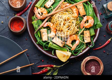 Délicieux spaghetti aux crevettes, à l'halloumi et au niébé dans une assiette Banque D'Images