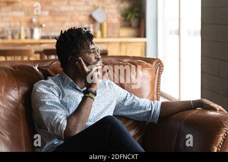 Joyeux jeune homme africain de race mixte parlant sur le téléphone portable. Banque D'Images