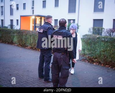 06 décembre 2020, Hessen, Francfort-sur-le-main: Des policiers parlent à l'un des derniers résidents du district de Gallus qui a quitté son appartement. Une bombe de 500 kg datant de la Seconde Guerre mondiale a été trouvée à proximité, qui doit être désamorcée au cours de la journée. En raison de la quantité d'explosifs et de la conception de la bombe britannique, un grand rayon d'évacuation était nécessaire. Photo: Frank Rumpenhorst/dpa Banque D'Images