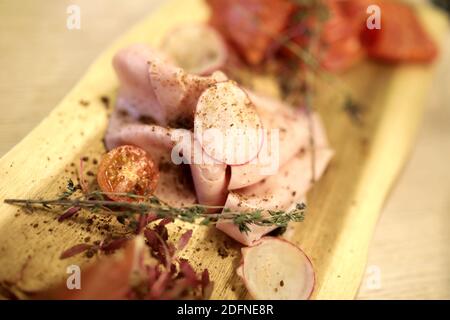 Tranches de jambon sur une assiette en bois au restaurant Banque D'Images