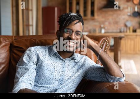 Portrait d'un homme africain charmant des années 30 se reposant sur un canapé. Banque D'Images