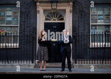 Photo du dossier datée du 14/05/20 publiée par 10 Downing Street du Premier ministre Boris Johnson et son associé Carrie Symonds à l'extérieur du 10 Downing Street à Londres, Se joindre aux applaudissements pour saluer les héros locaux pendant le Clap national pour que les soignants reconnaissent et soutiennent les travailleurs du NHS et les soignants qui luttent contre la pandémie du coronavirus. Le 13 décembre 2020 marque le premier anniversaire de la victoire aux élections générales de M. Johnson. Banque D'Images