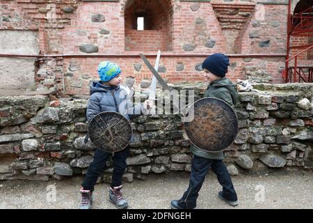 Deux garçons se battent avec des épées en automne Banque D'Images