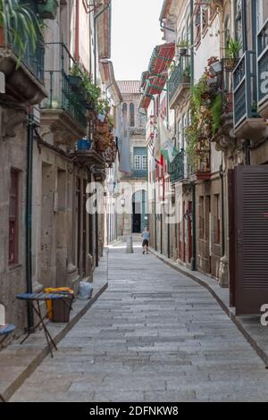 Guimaraes / Portugal - 12 09 2020 : vue sur une rue ancienne et étroite avec des bâtiments classiques sur le centre ville de Guimaraes, homme marchant et magasins Banque D'Images