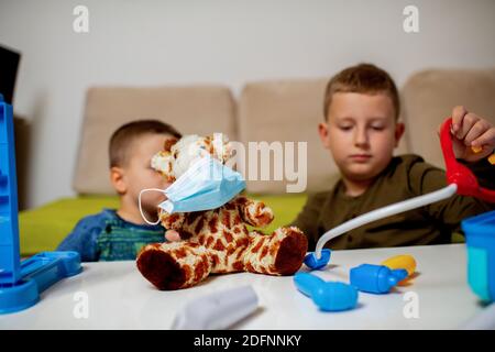 Les enfants à la maison mettent en quarantaine les jouets en peluche pour les protéger contre les virus pendant le coronavirus COVID-19 et l'éclosion de grippe. Enfants et maladie di Banque D'Images