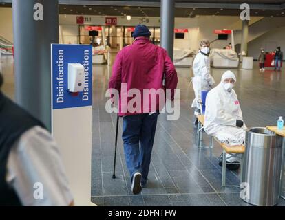 06 décembre 2020, Hessen, Francfort-sur-le-main: Un homme entre dans un hall d'exposition qui a été mis en place comme lieu de séjour lors de l'évacuation d'un quartier résidentiel. Jeudi 3 décembre, une bombe de 500 kg datant de la Seconde Guerre mondiale a été découverte à proximité, qui doit être désamorcée au cours de la journée. En raison de la quantité d'explosifs et de la conception de la bombe britannique, un grand rayon d'évacuation était nécessaire. Photo: Frank Rumpenhorst/dpa Banque D'Images