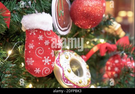 Jouet d'arbre de Noël sous forme de mitaine en fourrure rouge avec flocons de neige blancs. Banque D'Images
