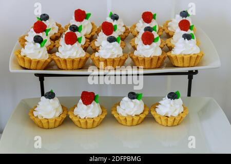 Mini-dessert aux tartes de fruits sur un stand à deux niveaux. Produit de boulangerie. Banque D'Images