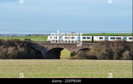 Classe 700 train de banlieue EMU traversant un pont routier en campagne entre Hitchin et Letchworth, Hertfordshire, Angleterre, Royaume-Uni Banque D'Images