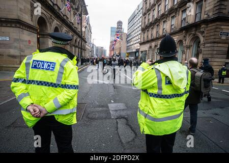 Manchester, Angleterre, Royaume-Uni. 6 décembre 2020. La police regarde comme un groupe de manifestants anti-verrouillage s'approche. Crédit : Callum Fraser/Alay Live News Banque D'Images
