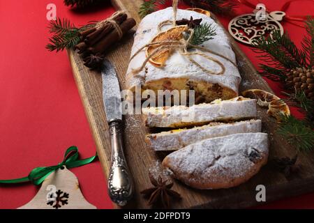 Noël savoureux stollen avec des fruits secs, des baies et des noix sur fond rouge. Gâteries traditionnelles allemandes. Gros plan Banque D'Images