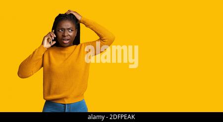 Confuse femme afro-américaine parlant au téléphone portable, réagissant émotionnellement à la conversation Banque D'Images