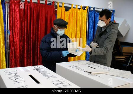 Bucarest, Roumanie. 6 décembre 2020. Un homme portant un masque facial se prépare à voter dans un bureau de vote à Bucarest, Roumanie, le 6 décembre 2020. Dans le cadre de mesures de protection spéciales, plus de 18 millions de Roumains devraient voter dimanche pour élire un nouveau Parlement bicaméral pour les quatre prochaines années. Credit: Cristian Cristel/Xinhua/Alay Live News Banque D'Images