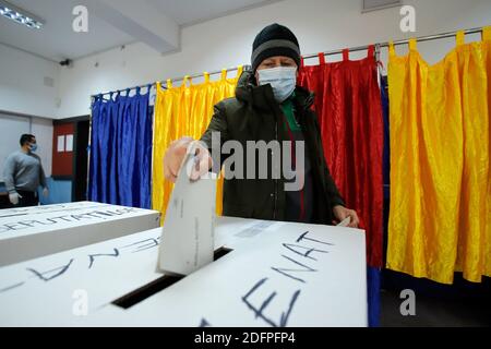 Bucarest, Roumanie. 6 décembre 2020. Un homme portant un masque projette son bulletin de vote dans un bureau de vote à Bucarest, en Roumanie, le 6 décembre 2020. Dans le cadre de mesures de protection spéciales, plus de 18 millions de Roumains devraient voter dimanche pour élire un nouveau Parlement bicaméral pour les quatre prochaines années. Credit: Cristian Cristel/Xinhua/Alay Live News Banque D'Images