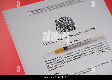 Stafford, Royaume-Uni - décembre 6 2020 : Vaccine endommagé Payments Act du gouvernement britannique et une seringue. Banque D'Images