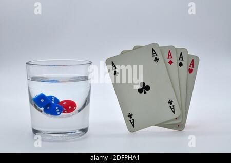 verre d'alcool contenant des dés rouges et bleus avec parfait quatre as sur fond blanc Banque D'Images