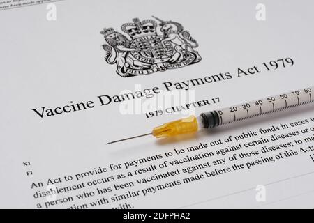 Stafford, Royaume-Uni - décembre 6 2020 : Vaccine endommagé Payments Act du gouvernement britannique et une seringue. Banque D'Images