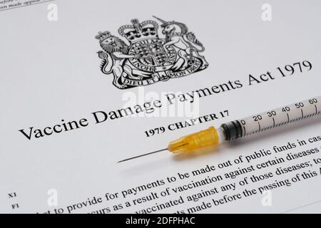 Stafford, Royaume-Uni - décembre 6 2020 : Vaccine endommagé Payments Act du gouvernement britannique et une seringue. Banque D'Images