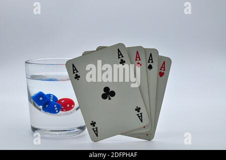 verre d'alcool contenant des dés rouges et bleus avec parfait quatre as sur fond blanc Banque D'Images