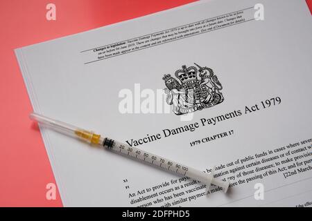 Stafford, Royaume-Uni - décembre 6 2020 : Vaccine endommagé Payments Act du gouvernement britannique et une seringue. Banque D'Images