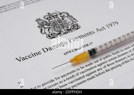 Stafford, Royaume-Uni - décembre 6 2020 : Vaccine endommagé Payments Act du gouvernement britannique et une seringue. Banque D'Images