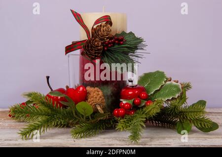 Décoration de Noël - une bougie entourée de branches d'épinette sur un substrat en bois. Banque D'Images