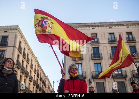 Barcelone, Catalogne, Espagne. 6 décembre 2020. Le manifestant est vu avec le drapeau de l'Espagne.Santiago Abascal, le président du parti d'extrême droite espagnol, VOX, a visité Barcelone ce dimanche 6 décembre, reçu par quelque 200 personnes, pour lire un manifeste et les articles de la Constitution, qui selon le parti sont menacés par le gouvernement actuel . Des groupes antifascistes se sont rendus sur la place de l'événement pour manifester contre VOX, mais la police les a empêchés de passer. Credit: Thiago Prudencio/DAX/ZUMA Wire/Alay Live News Banque D'Images