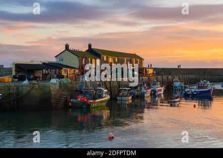 Lyme Regis, Dorset, Royaume-Uni. 6 décembre 2020. Météo Royaume-Uni. Le ciel brille orange au coucher du soleil au port de Cobb à Lyme Regis dans Dorset à la fin d'une journée froide avec des sorts ensoleillés. Crédit photo : Graham Hunt/Alamy Live News Banque D'Images