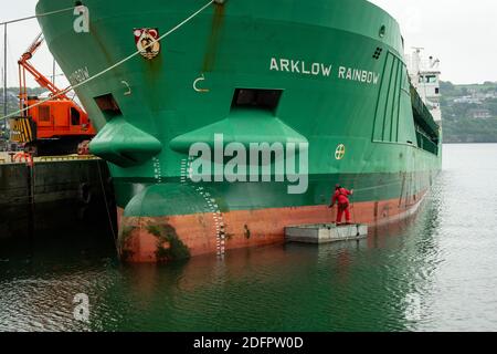 Le navire de cargaison Arklow Rainbow est peint en vert par un dyer mâle ou un peintre peint avec une petite brosse dans le port de Kinsale, en Irlande Banque D'Images