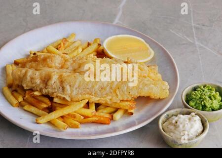 poisson et frites avec coin de citron, petits pois et sauce tartare Banque D'Images
