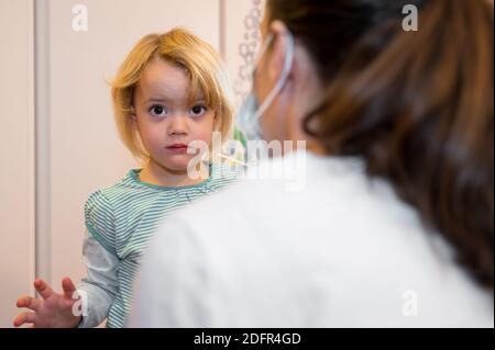 Fille blonde ayant un écouvillon oropharyngé inséré pour la détection de covid 19. Banque D'Images