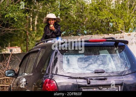 Le petit Tajik joue sur une voiture à Hisor, au Tadjikistan Banque D'Images