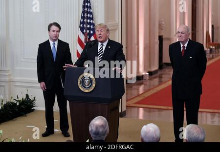 Le président américain Donald Trump, au centre, parle comme Brett Kavanaugh, juge associé de la Cour suprême des États-Unis, à gauche, Et Anthony Kennedy, ancien juge associé de la Cour suprême des États-Unis, écoute lors d'une cérémonie d'assermentation dans la salle est de la Maison Blanche à Washington, D.C., aux États-Unis, le lundi 8 octobre 2018. Photo par Olivier Douliery/Abaca Press Banque D'Images