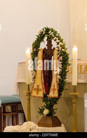 Croix chrétienne en bois dans une petite chapelle avec deux bougies allumées d'ailleurs Banque D'Images