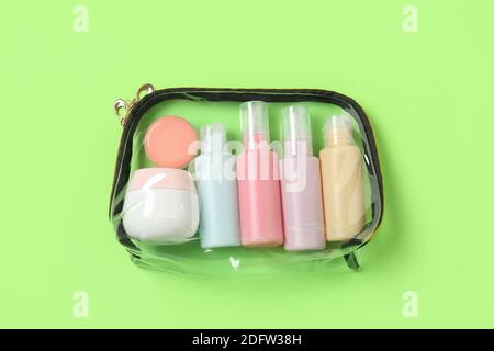 Sac transparent avec produits cosmétiques de voyage sur fond de couleur Banque D'Images