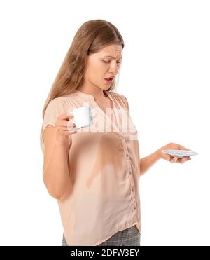 Jeune femme stressée avec taches de café sur sa chemise arrière-plan blanc Banque D'Images