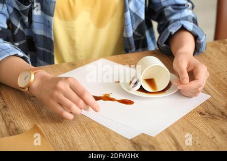 Femme avec des taches de café sur son t-shirt et le café renversé dans la cuisine Banque D'Images