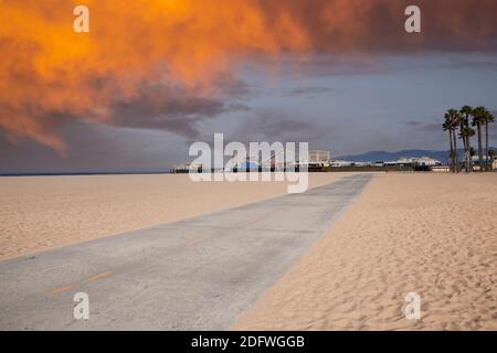 Célèbre piste cyclable de la plage de Santa Monica et jetée d'amusement avec ciel de coucher de soleil. Banque D'Images