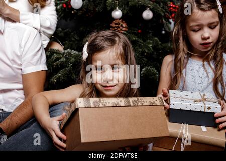 Gros plan vue rognée portrait de sœurs jolie gaie gaie Les familles passent des vacances de Noël et les filles échangent des cadeaux à l'intérieur apar Banque D'Images