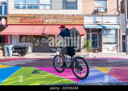 Un homme qui fait du vélo dans le marché de Kensington à Toronto, au Canada Banque D'Images