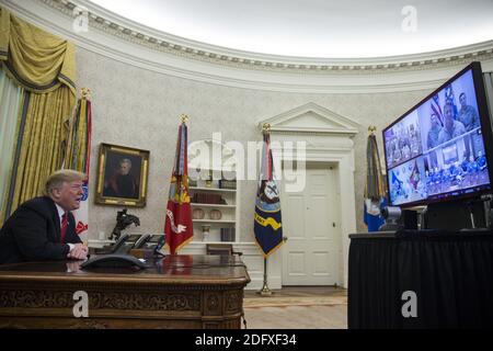 Le président Donald Trump fait un appel vidéo à des membres de l'Armée de terre, du corps des Marines, de la Marine, de l'Armée de l'Air et de la Garde côtière stationnés dans le monde entier dans le Bureau ovale de la Maison Blanche à Washington, D.C., aux États-Unis, le 25 décembre 2018. Photographe: Zach Gibson/Bloomberg Banque D'Images