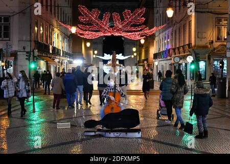 Lisbonne, Portugal. 03ème décembre 2020. Un musicien portant un masque de visage joue un violoncelle au milieu de Rua de Augusta dans le district de Baixa.Portugal a mis en place un règlement d'urgence qui interdit le mouvement des personnes entre les différents districts et les municipalités du pays pendant les célébrations de Noël et le nouvel an. Crédit : SOPA Images Limited/Alamy Live News Banque D'Images